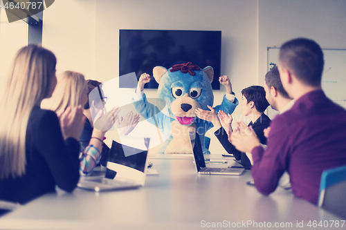 Image of boss dresed as bear having fun with business people in trendy of