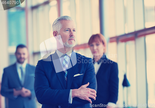 Image of senior business man with his team at office