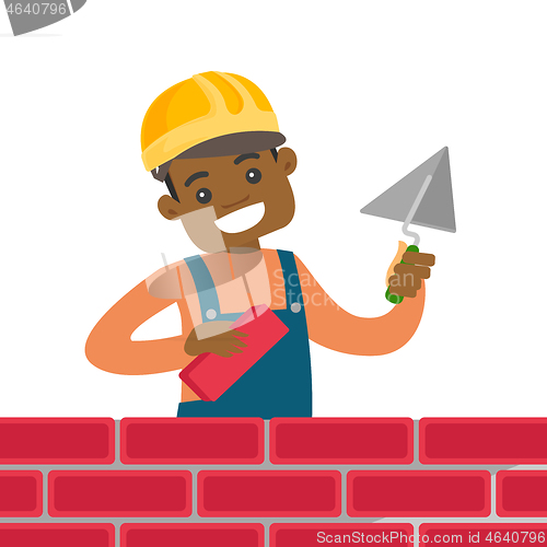 Image of African-american bricklayer building a brick wall.