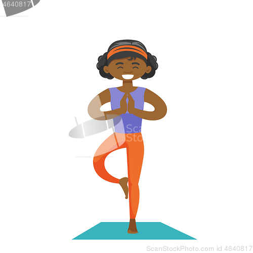 Image of African-american woman practicing yoga tree pose.