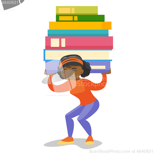 Image of College student carrying a heavy pile of books.