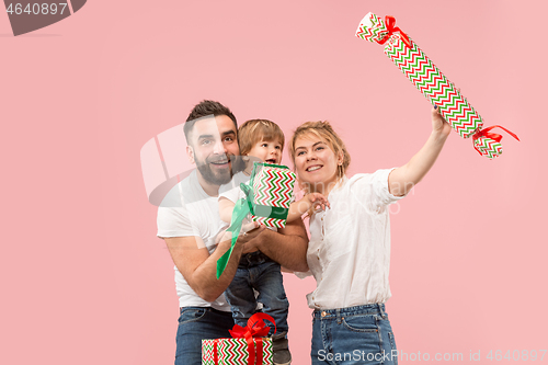 Image of happy family with kid together and smiling at camera isolated on pink