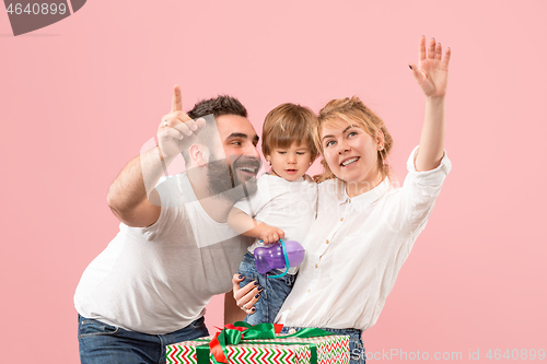 Image of happy family with kid together and smiling at camera isolated on pink