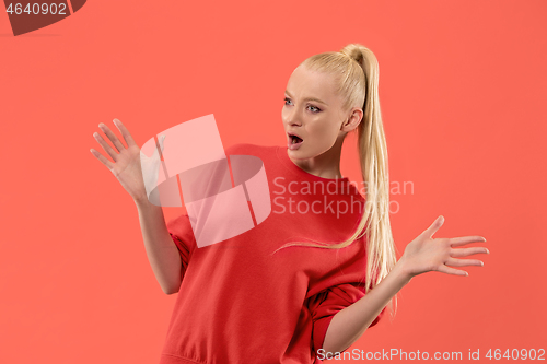 Image of Beautiful woman looking suprised isolated on coral