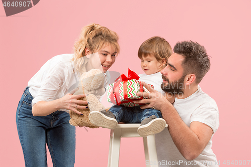 Image of happy family with kid together and smiling at camera isolated on pink