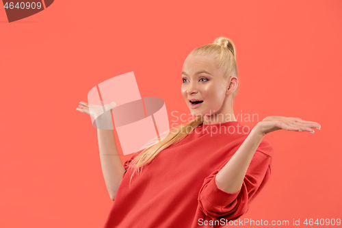 Image of Beautiful woman looking suprised isolated on coral