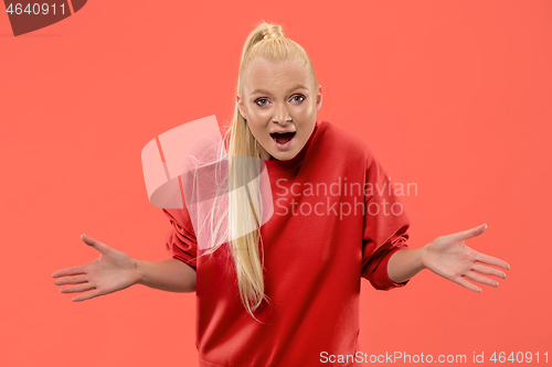 Image of Beautiful woman looking suprised isolated on coral