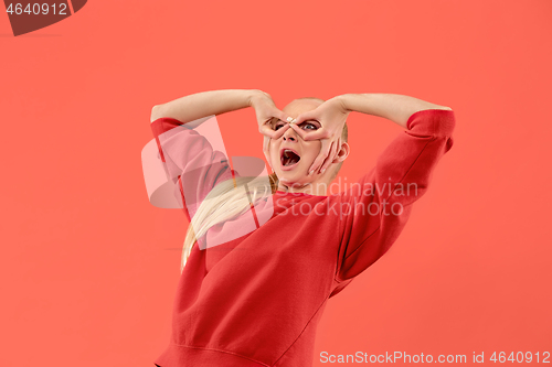 Image of Beautiful woman looking suprised isolated on coral