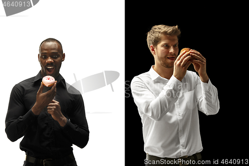 Image of Men eating a hamburger and donut on a black and white background