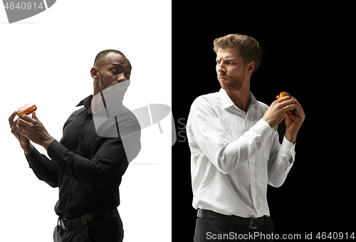 Image of Men eating a hamburger and donut on a black and white background