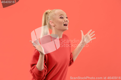 Image of Beautiful woman looking suprised isolated on coral