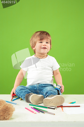 Image of Portrait of happy little boy over green background