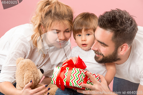 Image of happy family with kid together and smiling at camera isolated on pink