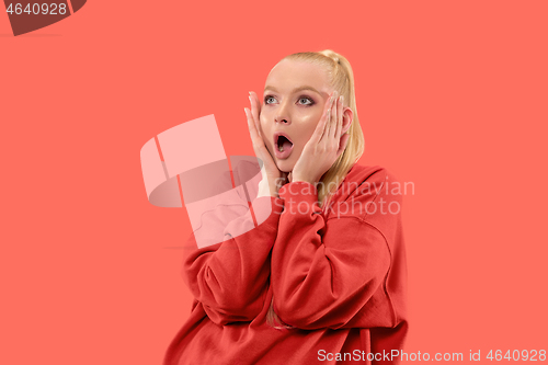 Image of Beautiful woman looking suprised isolated on coral