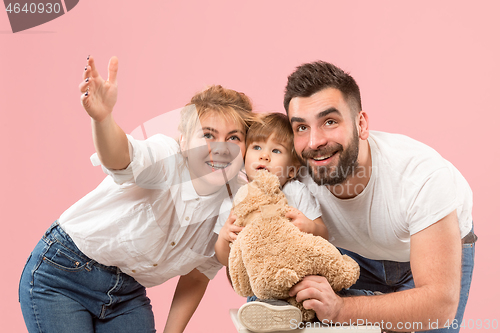 Image of happy family with kid together and smiling at camera isolated on pink