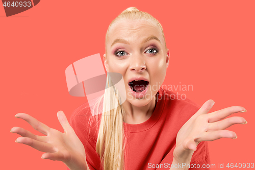 Image of Beautiful woman looking suprised isolated on coral