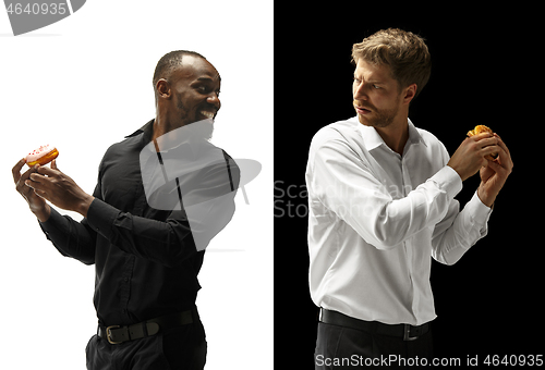 Image of Men eating a hamburger and donut on a black and white background