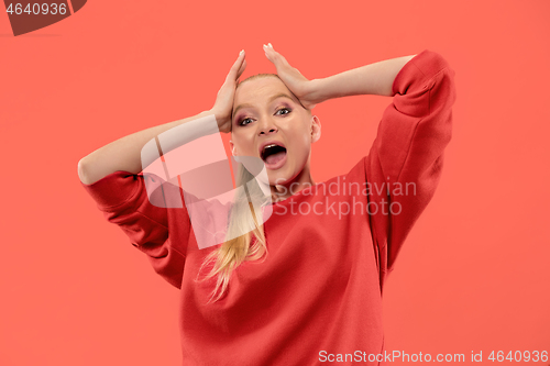 Image of Beautiful woman looking suprised isolated on coral