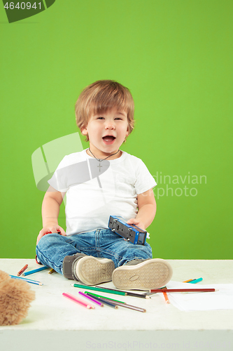 Image of Portrait of happy little boy over green background