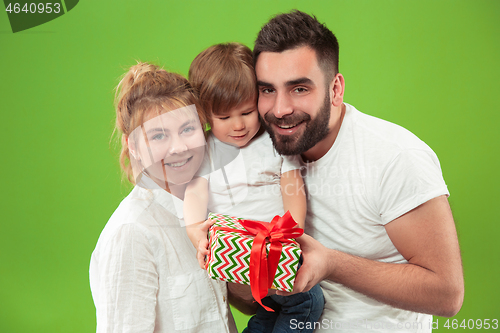 Image of happy family with kid together and smiling at camera isolated on green