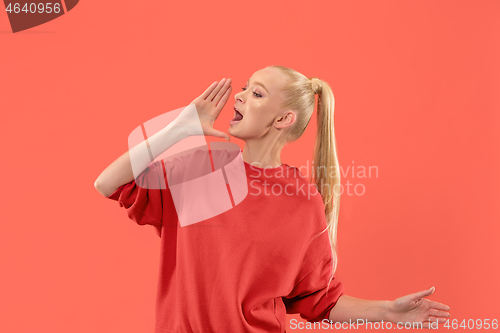 Image of Isolated on coral young casual woman shouting at studio