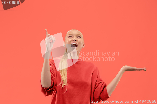 Image of Beautiful woman looking suprised isolated on coral