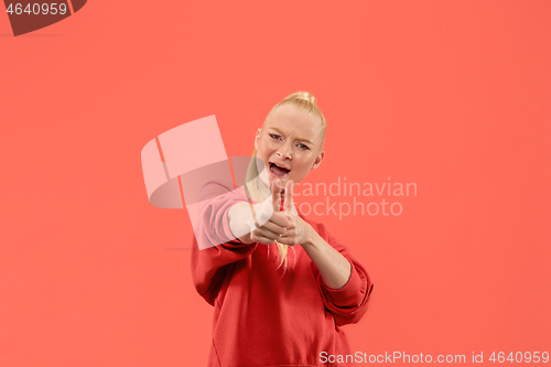 Image of The happy business woman standing and smiling against coral background.