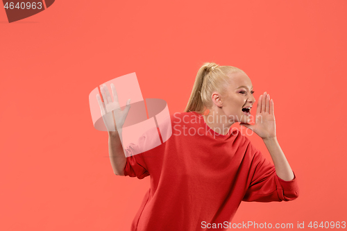 Image of Isolated on coral young casual woman shouting at studio