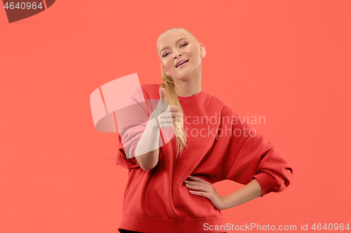 Image of The happy business woman standing and smiling against coral background.