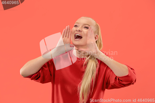 Image of Isolated on coral young casual woman shouting at studio