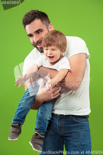 Image of happy family with kid together smiling at camera isolated on green