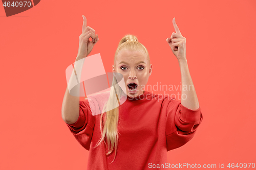 Image of Beautiful woman looking suprised isolated on coral