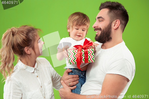 Image of happy family with kid together and smiling at camera isolated on green