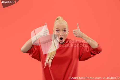 Image of Beautiful woman looking suprised isolated on coral