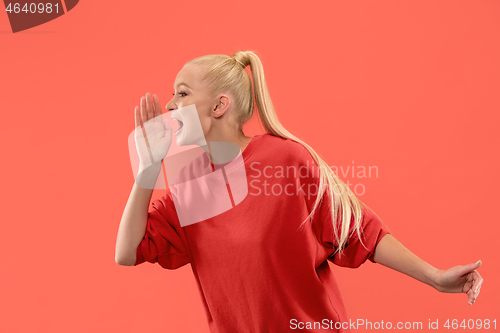 Image of Isolated on coral young casual woman shouting at studio