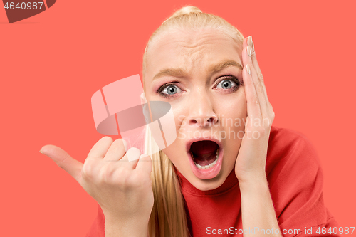 Image of Beautiful woman looking suprised isolated on coral