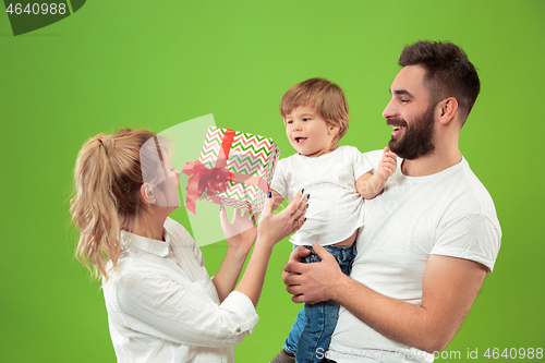 Image of happy family with kid together and smiling at camera isolated on green