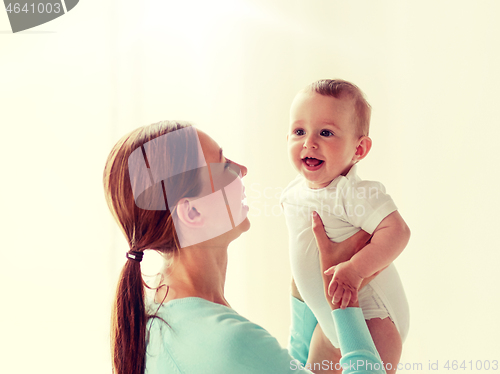 Image of happy young mother with little baby at home