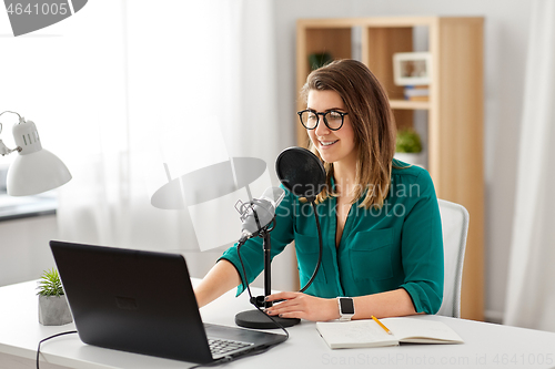 Image of woman with microphone recording podcast at studio