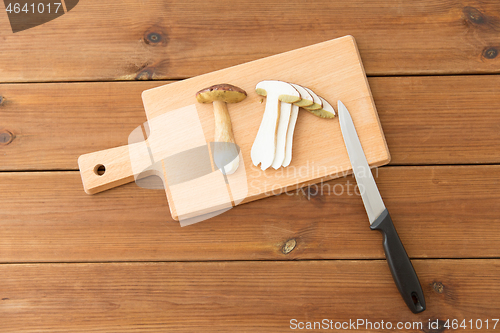 Image of edible mushrooms, kitchen knife and cutting board