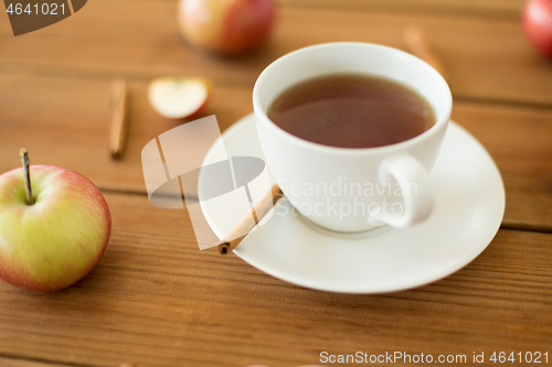 Image of cup of tea with apples and cinnamon on table