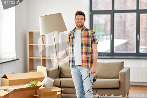 Image of happy man with floor lamp moving to new home