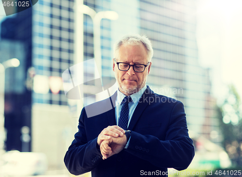 Image of senior businessman checking time on his wristwatch