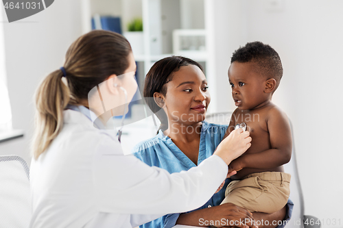 Image of doctor with stethoscope listening baby at clinic