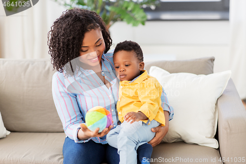 Image of mother and baby playing with ball at home