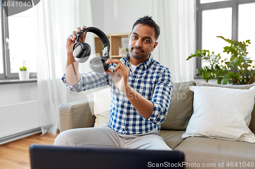 Image of male blogger with headphones videoblogging at home