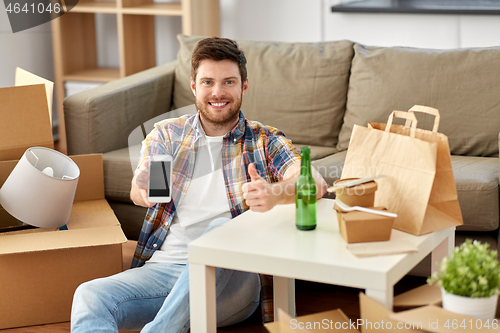 Image of man with smartphone and takeaway food moving