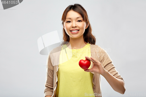 Image of happy asian woman holding red heart