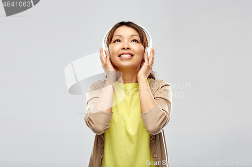 Image of asian woman in headphones listening to music