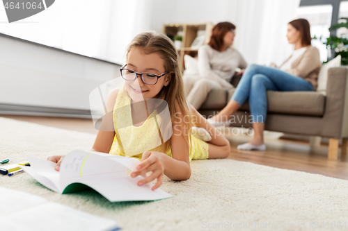 Image of student girl with notebook lying on floor at home